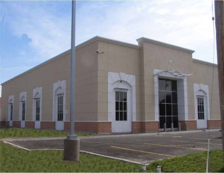 A large building with a lot of windows and a parking lot in front of it