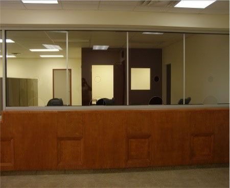 An office with a wooden counter and a glass wall