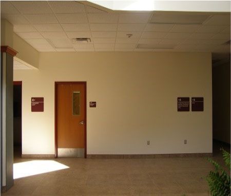 An empty hallway with a door and two signs on the wall