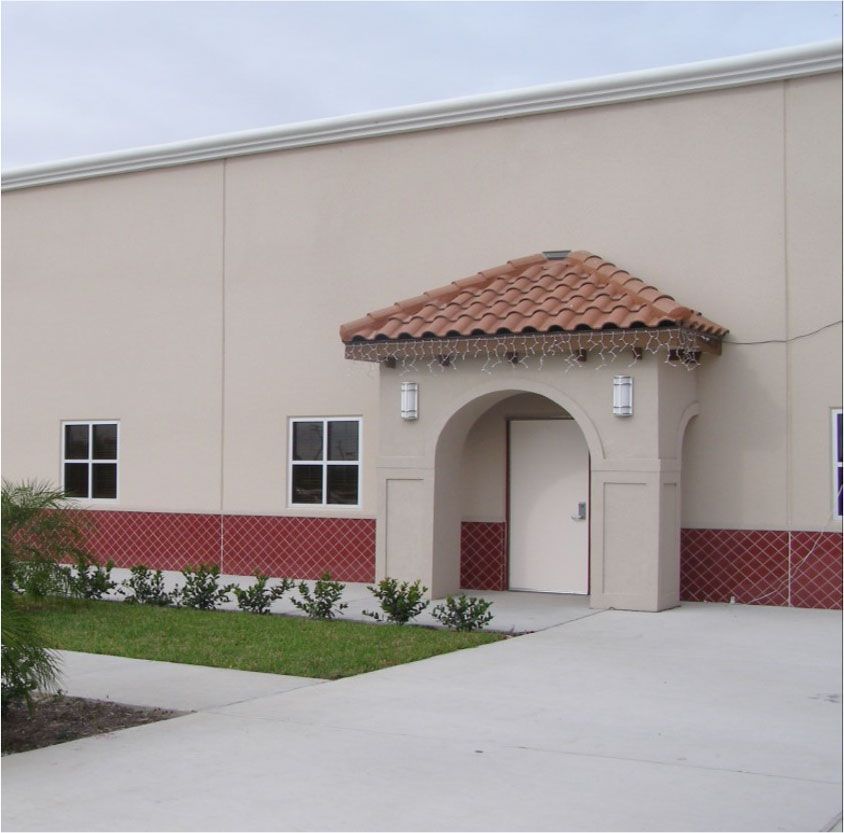 A white building with red trim and a door