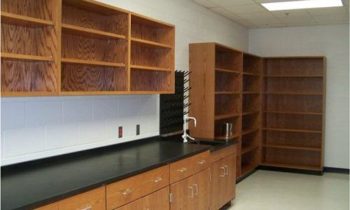 A kitchen with a black counter top and wooden cabinets