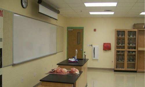 A classroom with a white board and a clock on the wall
