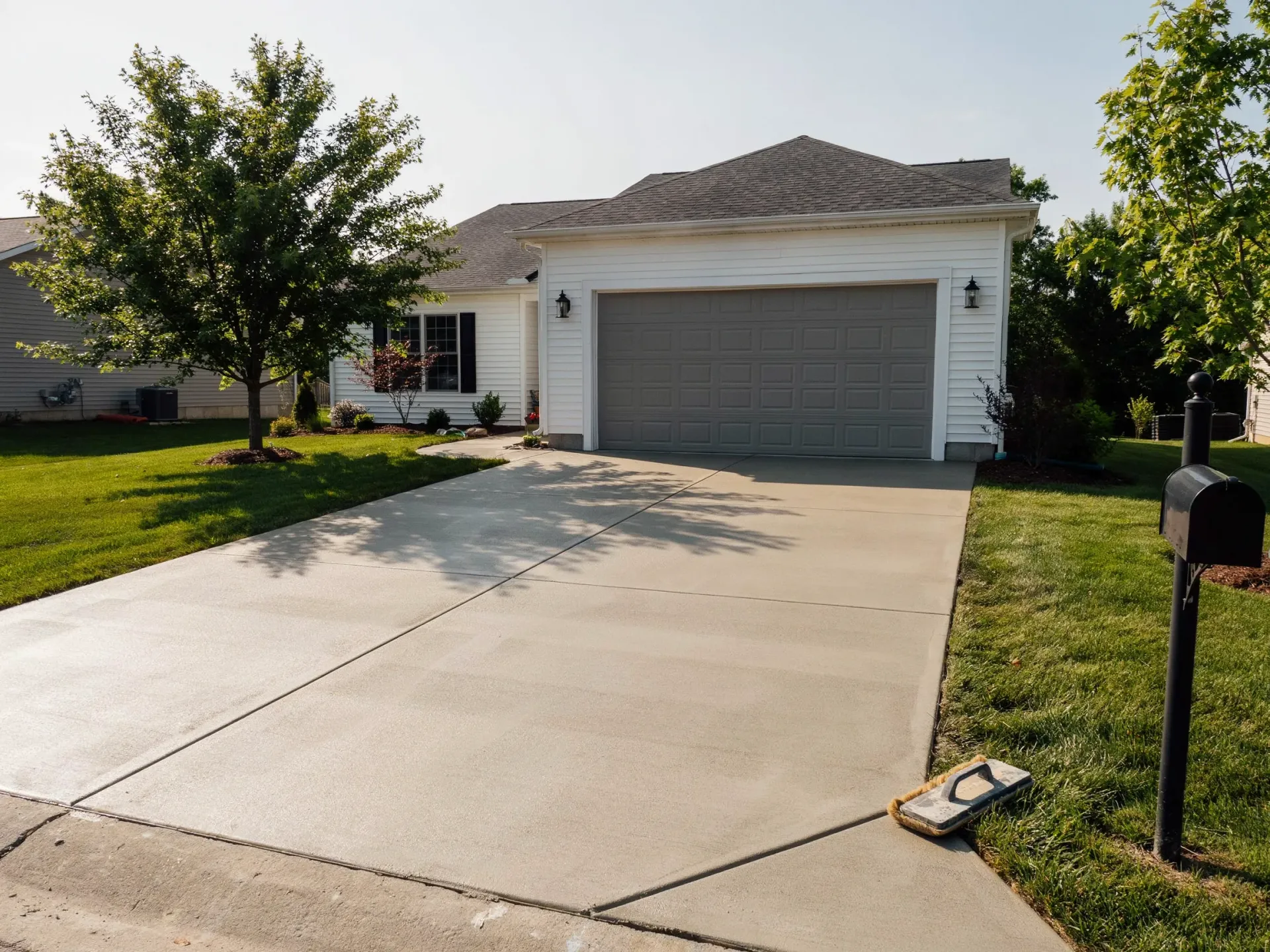 Suburban house with a two-car garage and concrete driveway in daylight