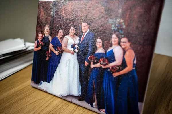 A picture of a bride and groom and their bridesmaids on a table.