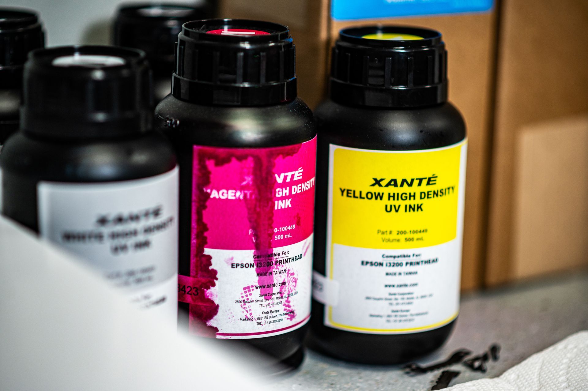 A bunch of bottles of ink are sitting on a table.