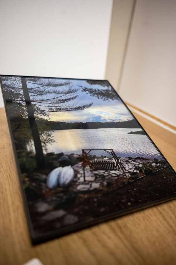A picture of a lake is sitting on a wooden table.