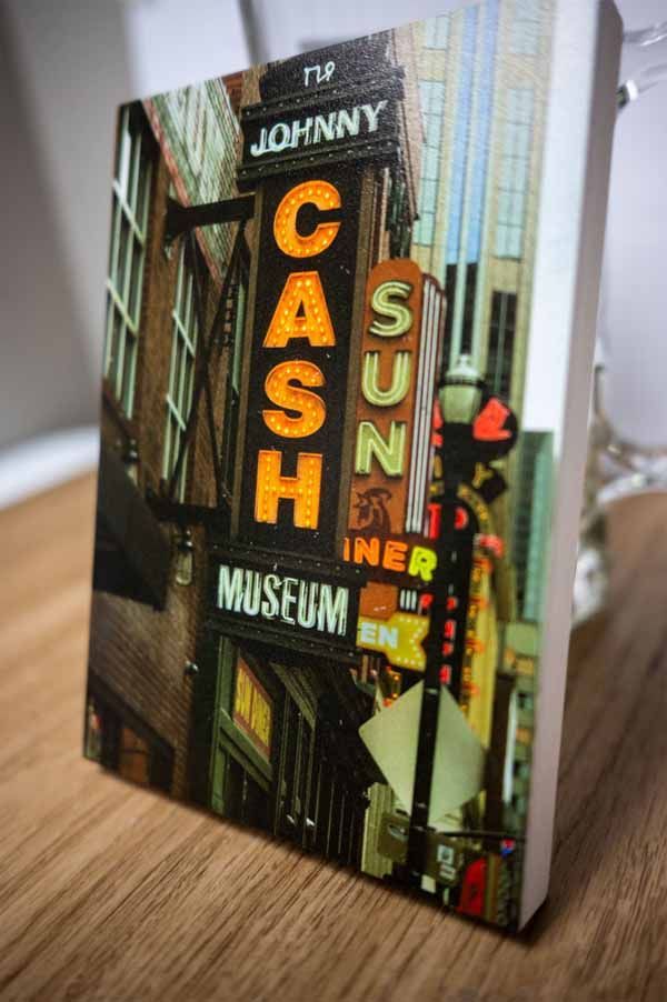 A book titled cash museum is sitting on a wooden table.