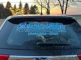 A car with a sticker on the back window that says g.i. joe 's extreme cleaning llc.