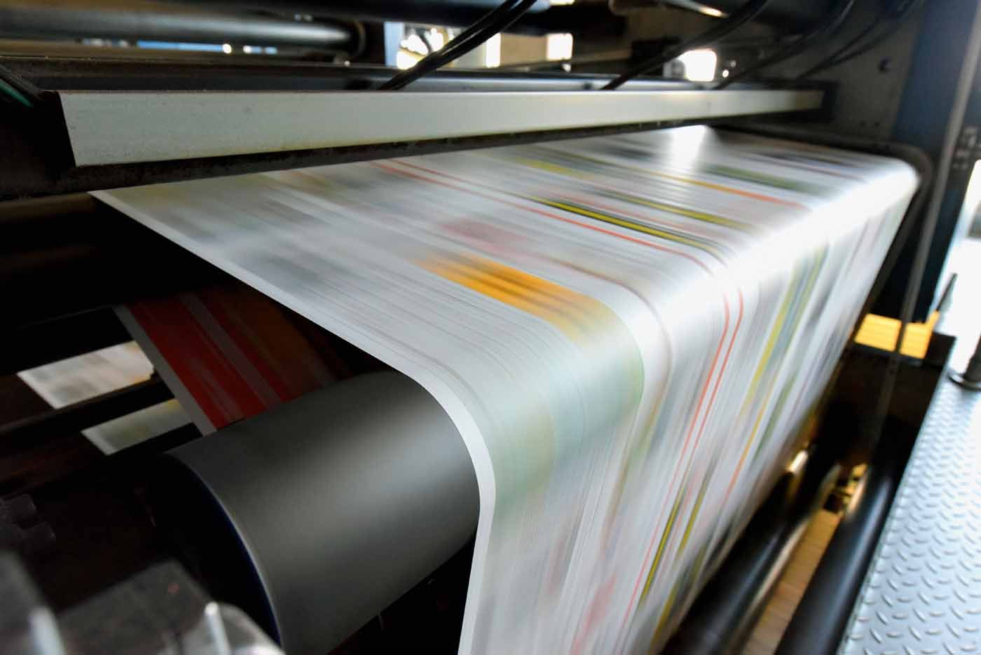 A newspaper is being printed on a printing machine