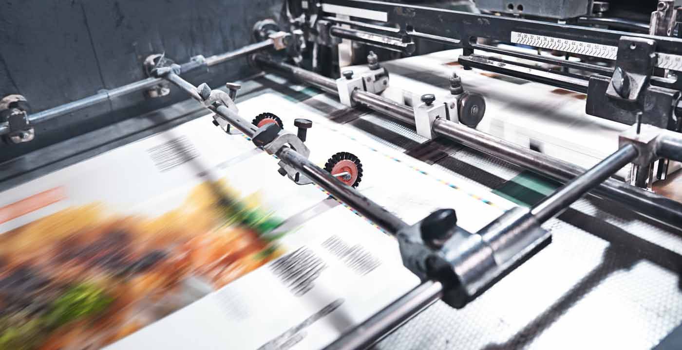 A printing machine is printing a picture of a hamburger on a piece of paper.