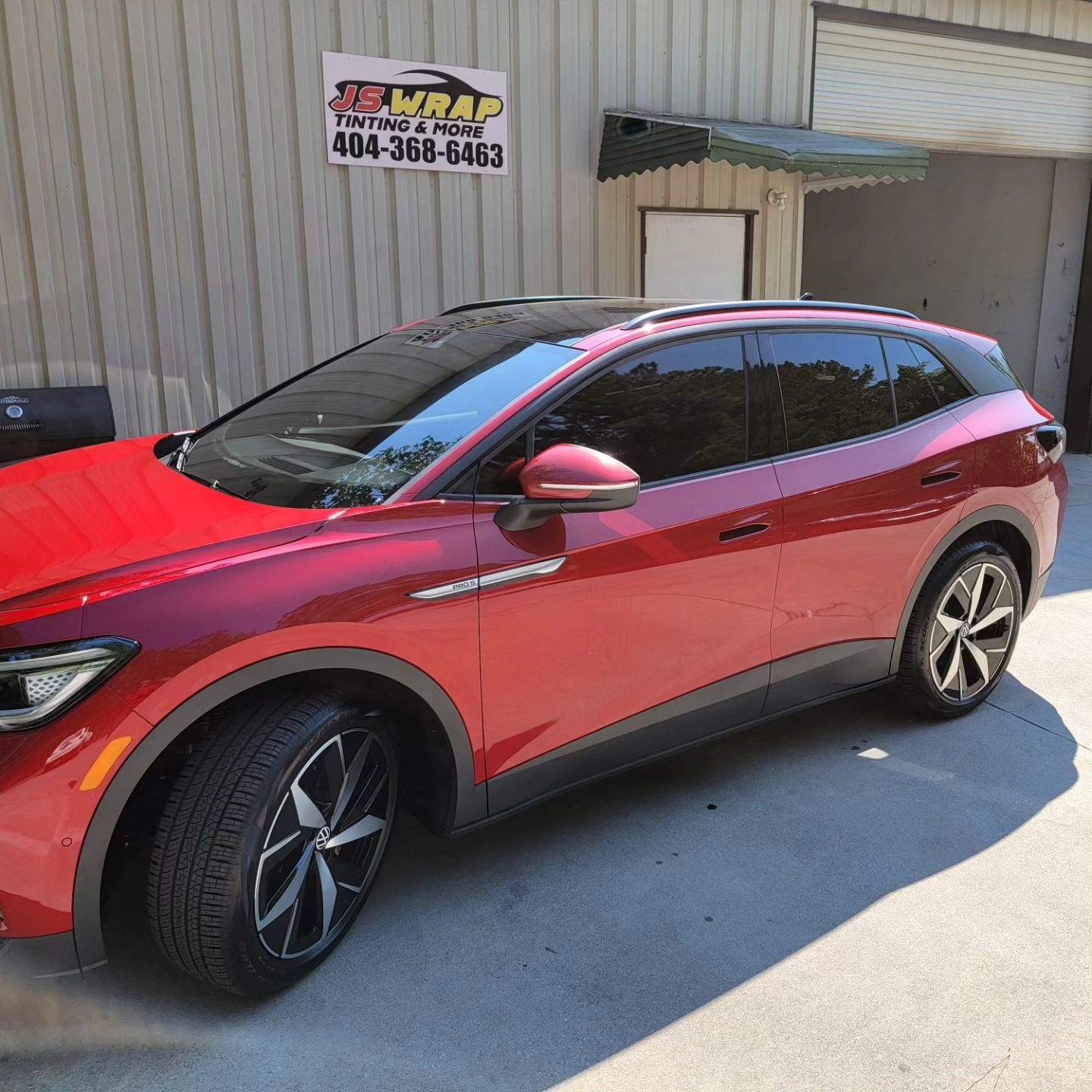 A red car is parked in front of a building.
