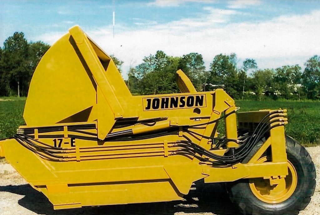 A yellow johnson tractor is parked in a field