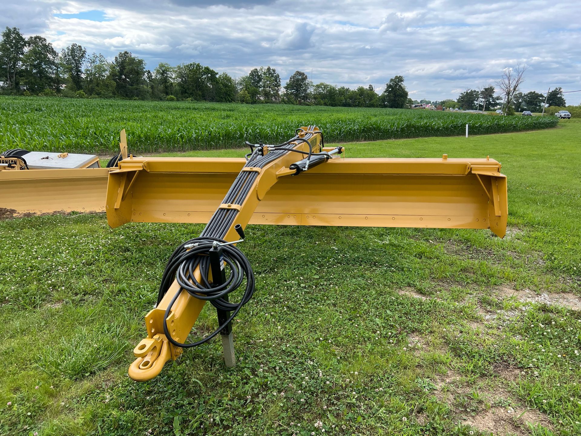 A yellow tractor is parked in a grassy field.