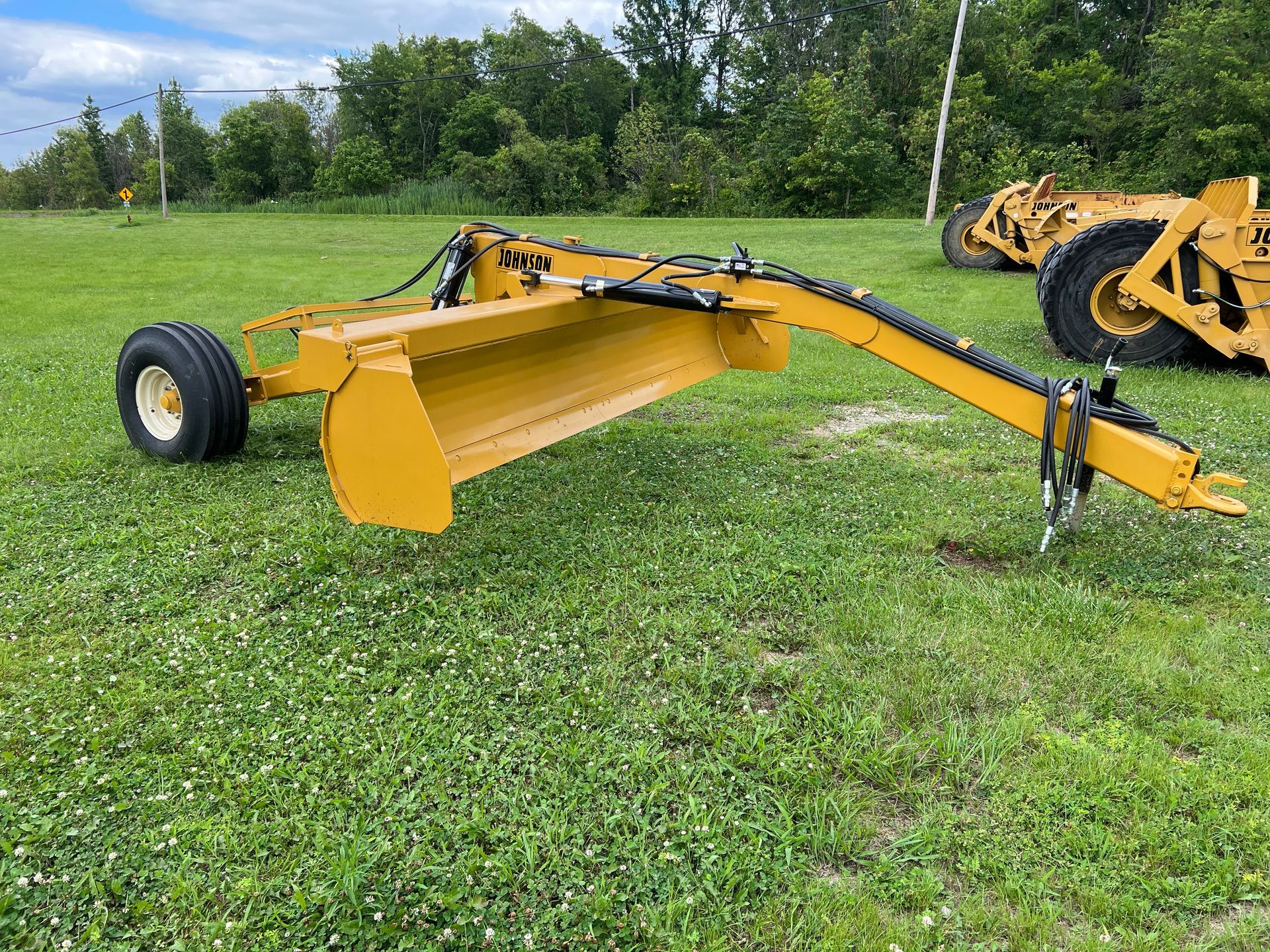 A yellow tractor is parked in a grassy field.