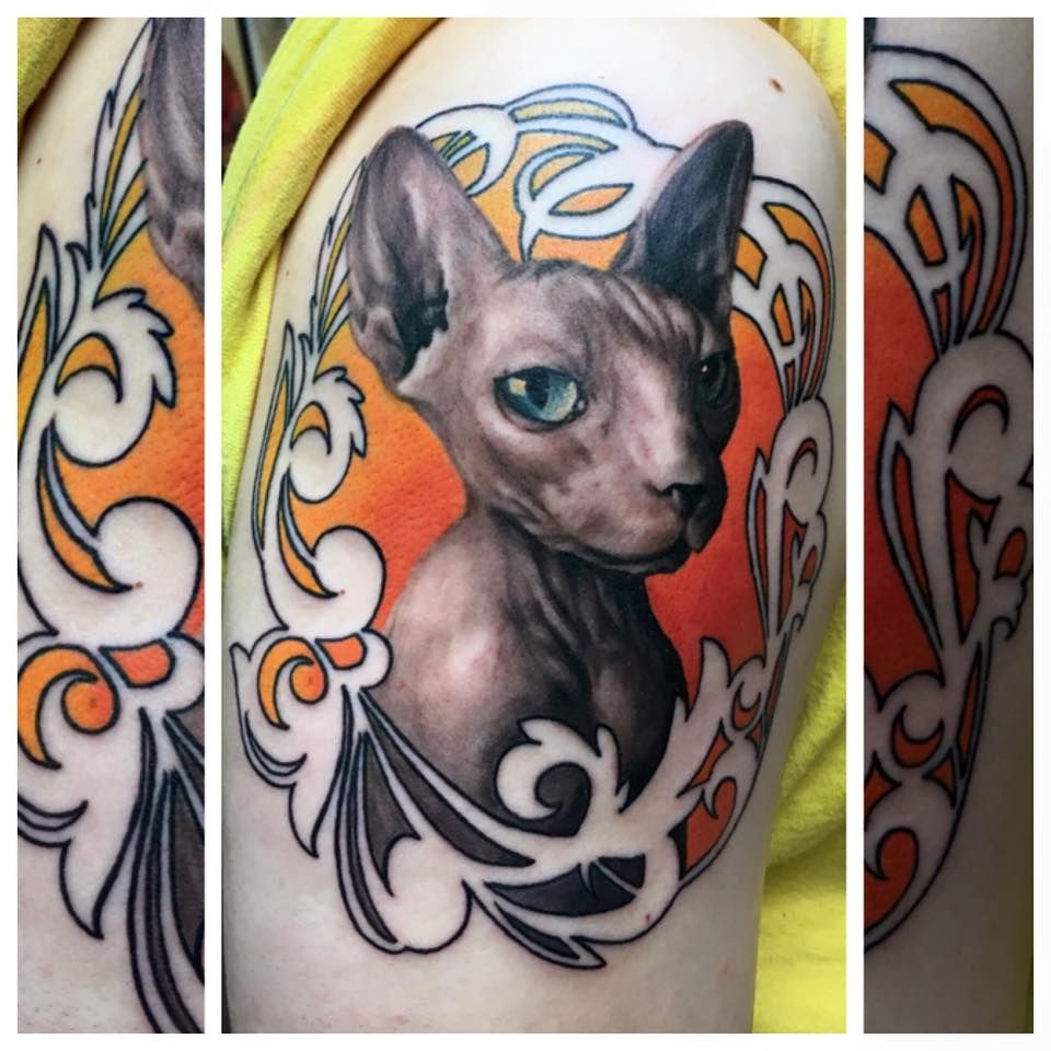 A tattoo of a hairless cat with green eyes