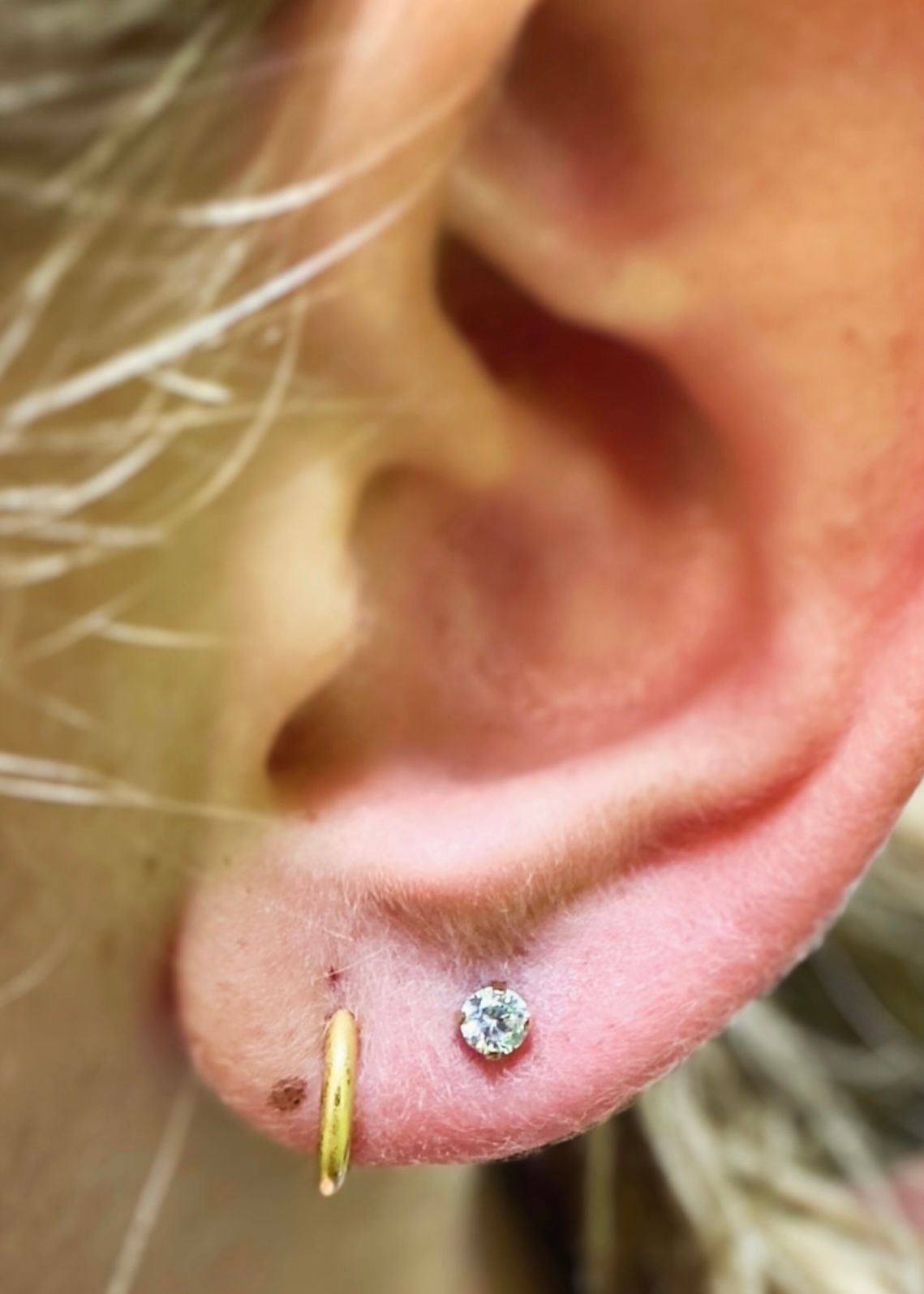 A close up of a person 's ear with earrings.