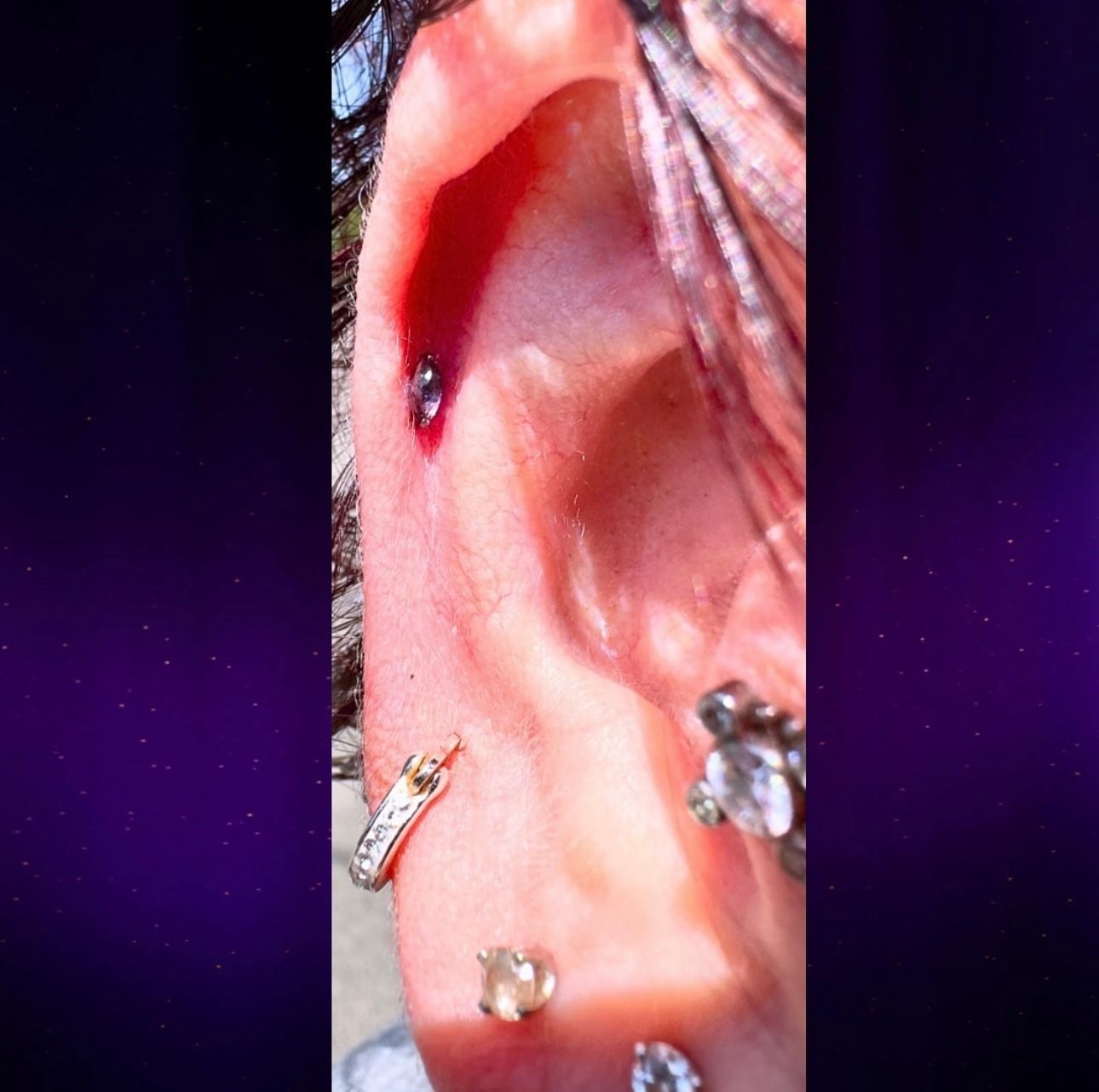 A close up of a person 's ear with piercings and earrings.