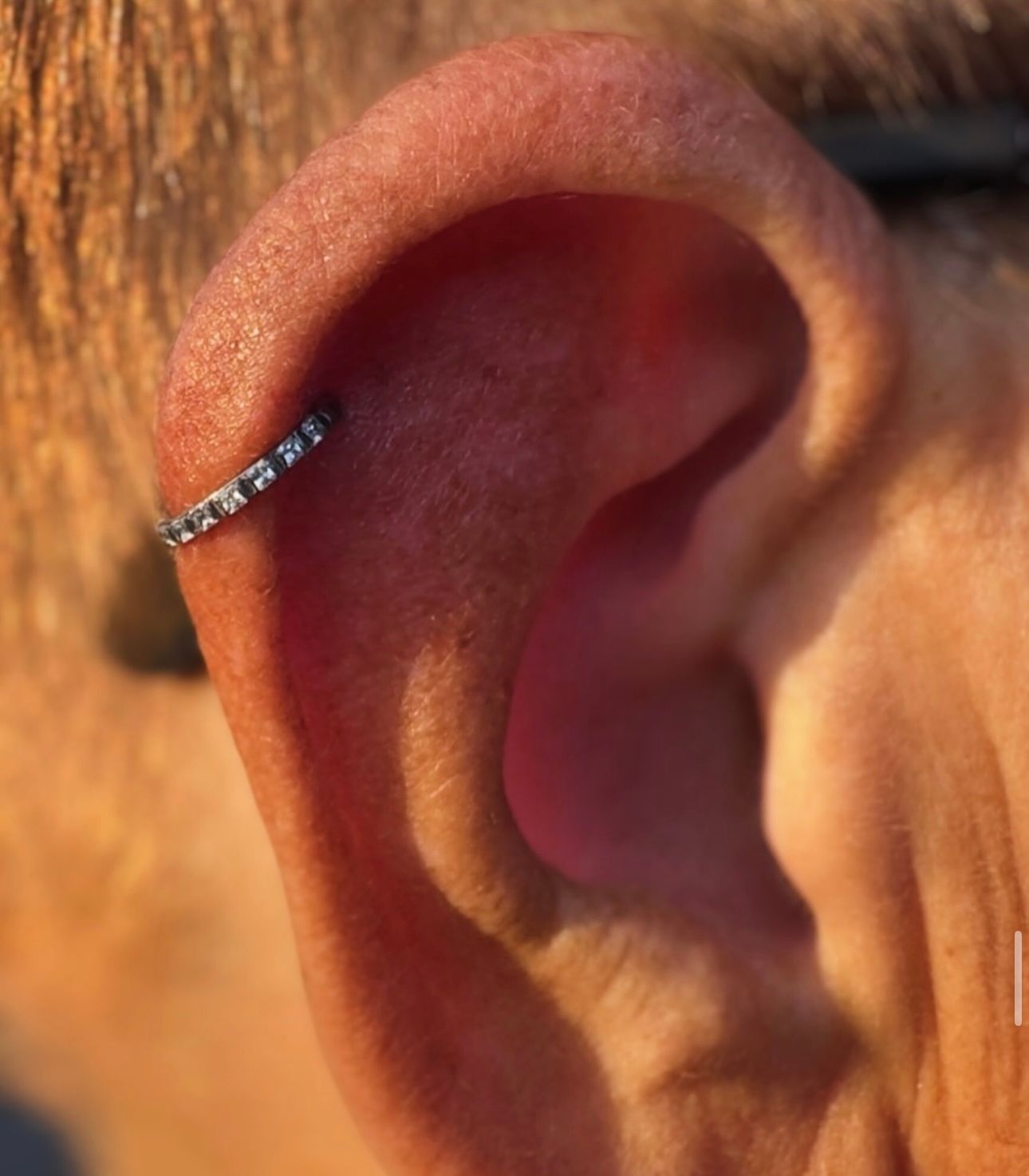 A close up of a person 's ear with a ring on it