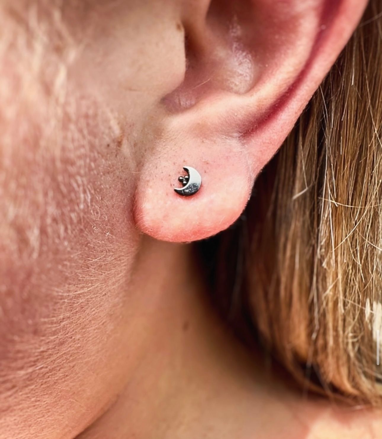 A close up of a person 's ear with a pair of earrings.