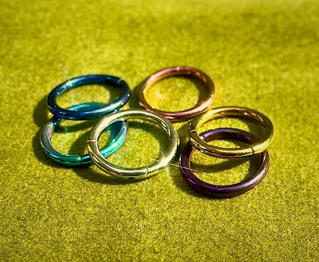 A group of colorful rings are stacked on top of each other on a green surface.