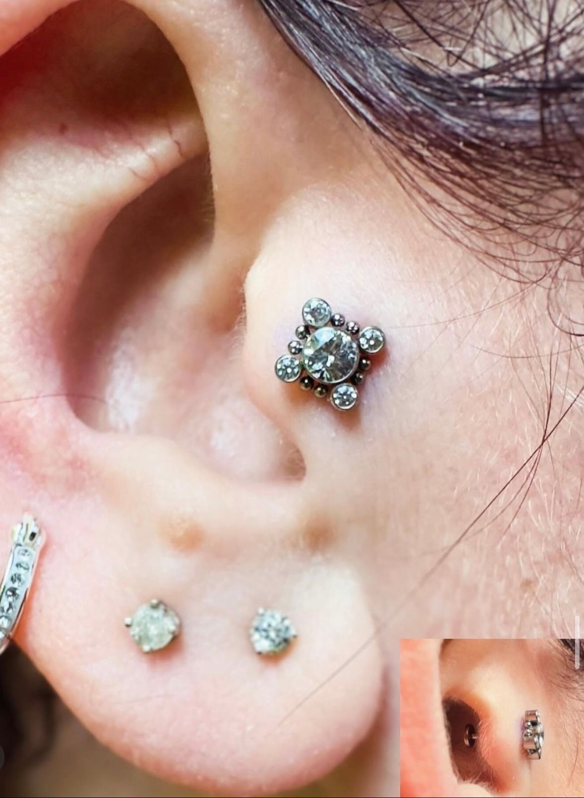 A close up of a woman 's ear with earrings on it