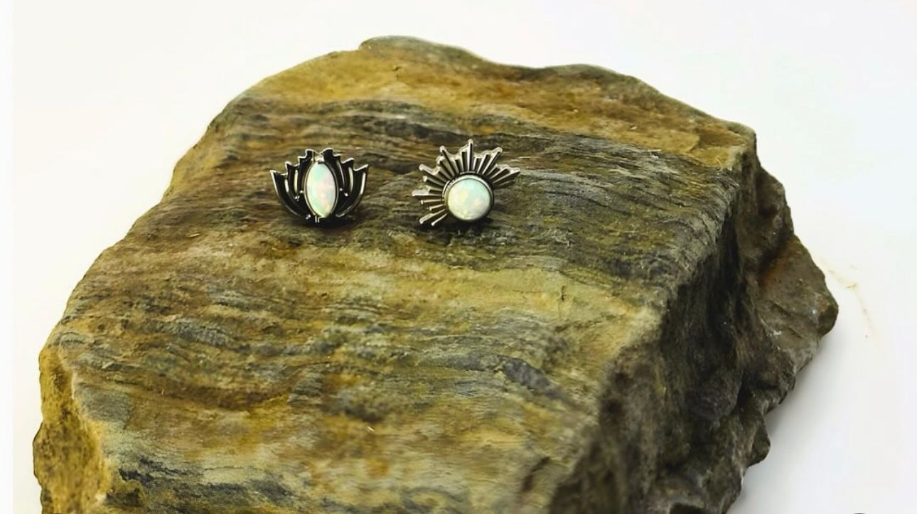 A pair of earrings are sitting on top of a rock.