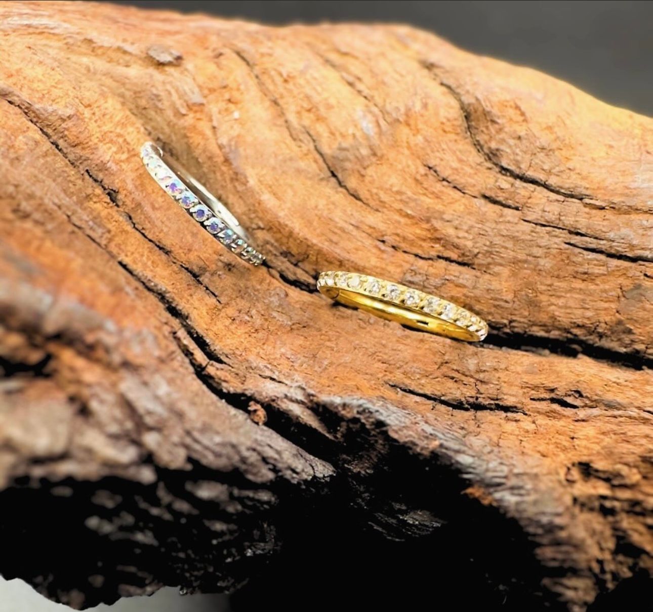 Two rings are sitting on a piece of wood.