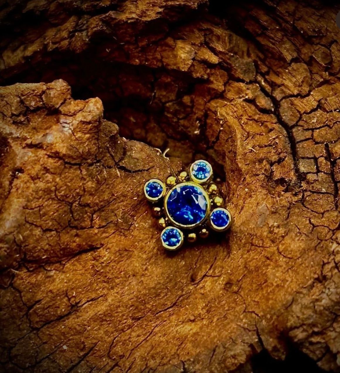 A close up of a pendant on a piece of wood.