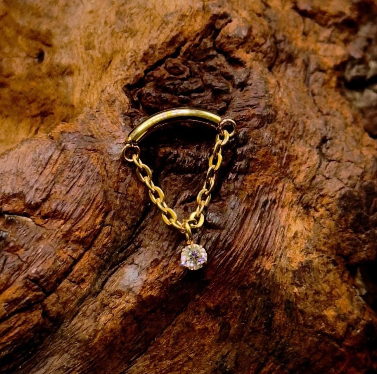 A gold chain with a diamond hanging from it