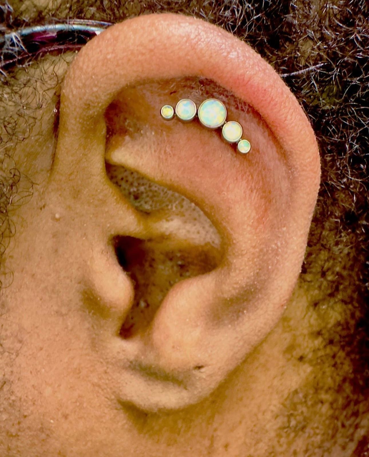 A close up of a person 's ear with a piercing