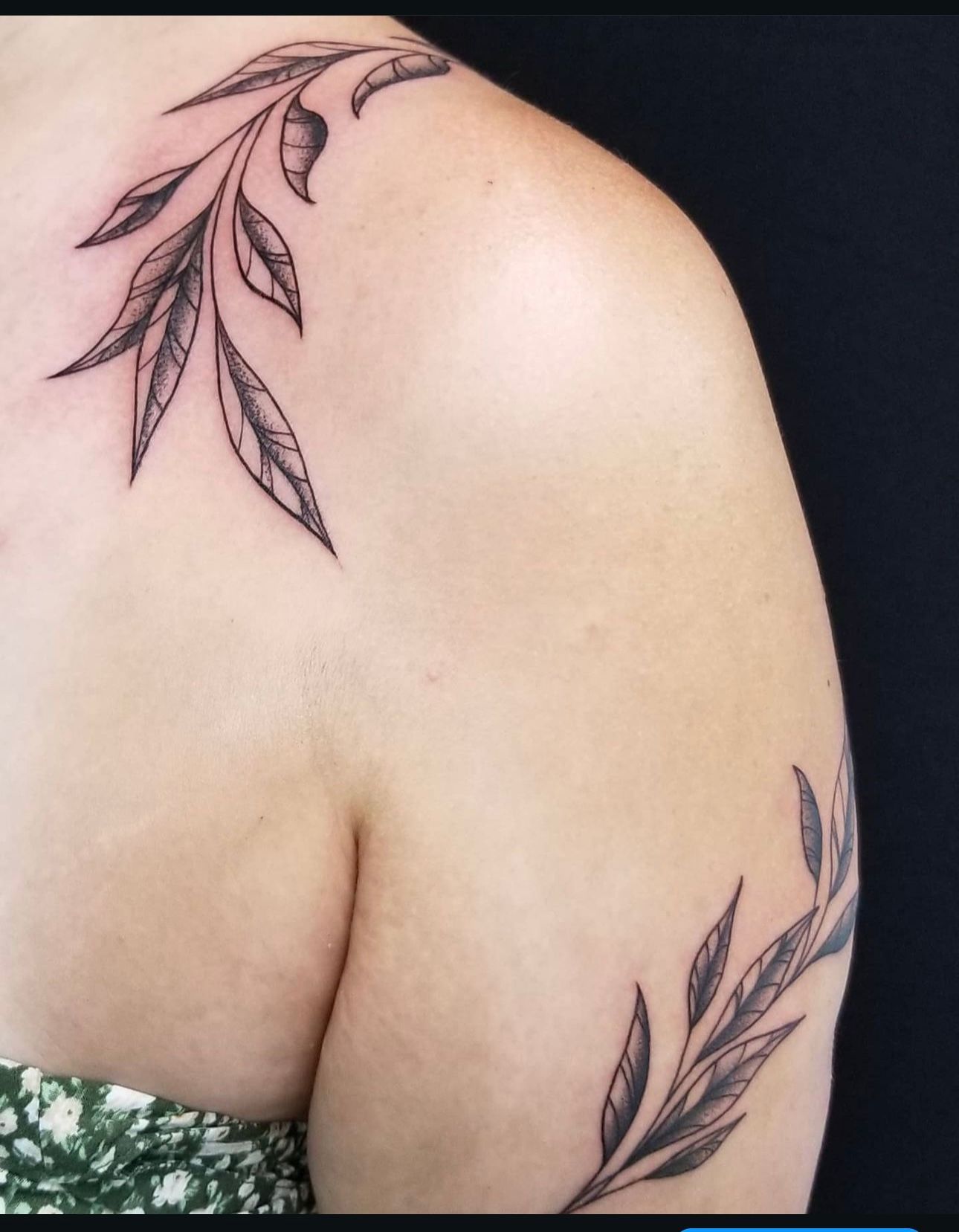 A woman has a tattoo of leaves on her shoulder
