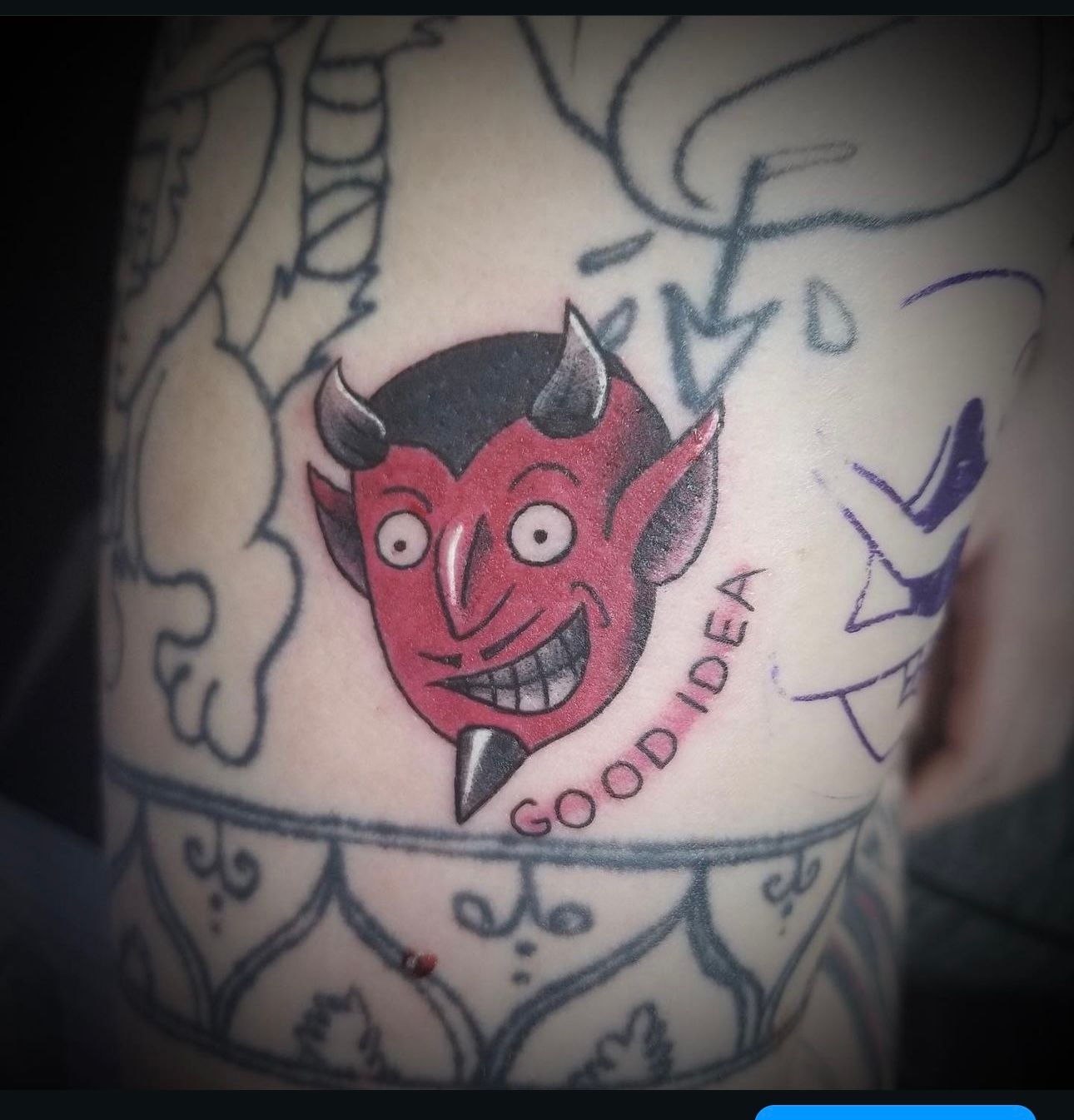 A tattoo of a devil with horns and the words good idea
