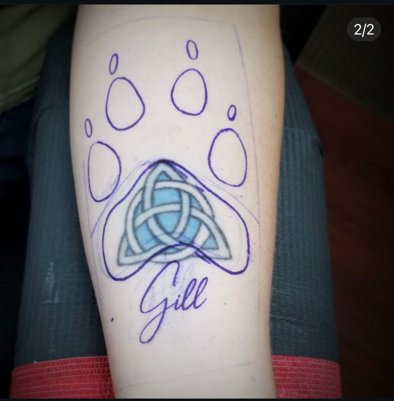 A tattoo of a paw print with the name gill on it