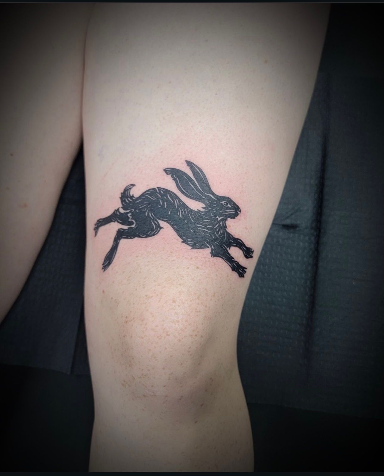 A person has a tattoo of a rabbit on their leg