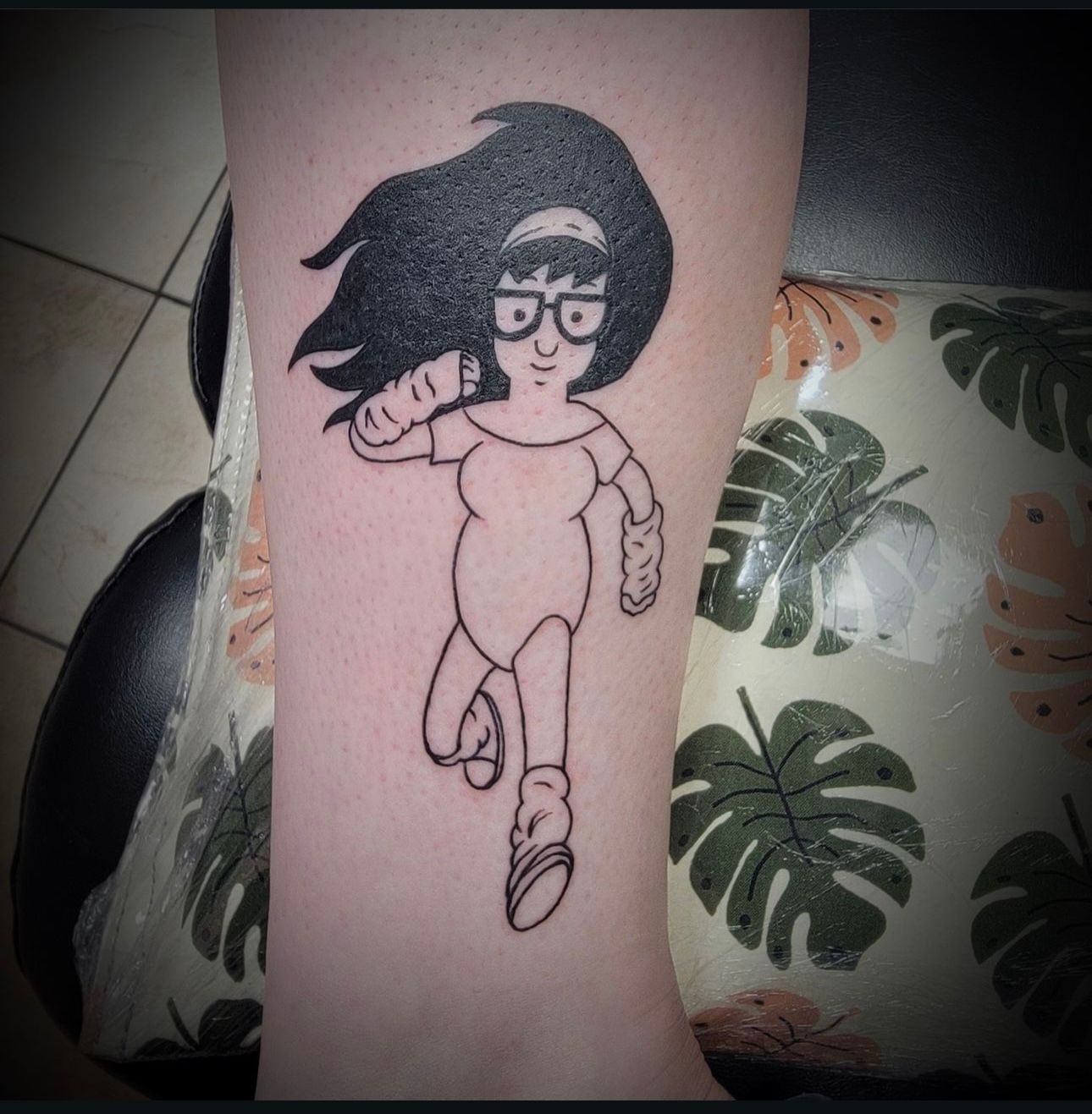 A person has a tattoo of a cartoon character on their arm