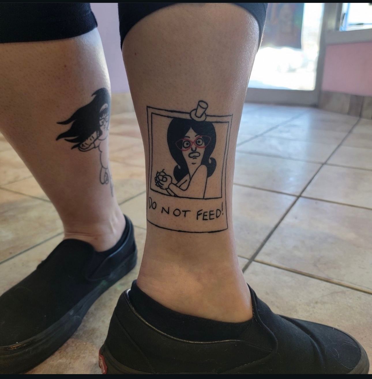A person has a tattoo on their leg that says do not feed
