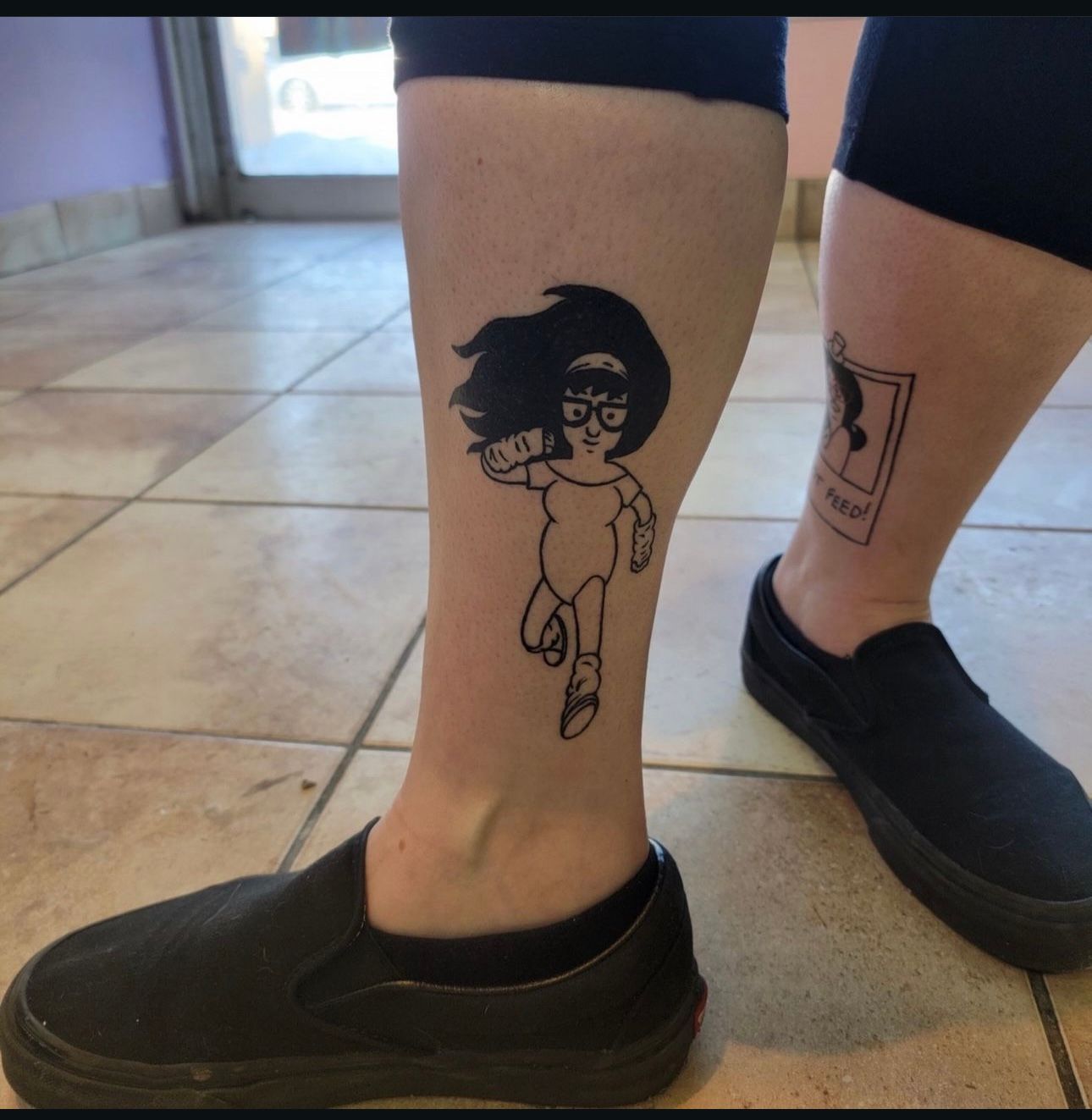 A person has a tattoo of a girl on their leg