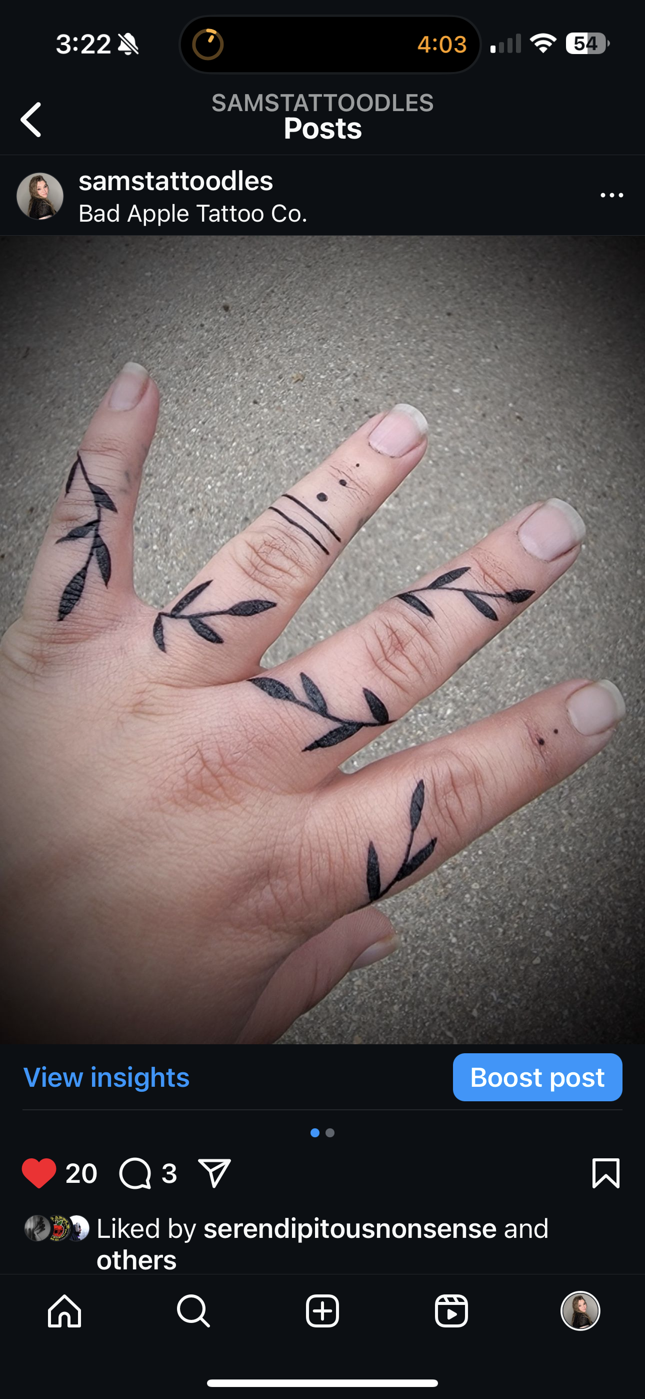 A close up of a person 's hand with a tattoo on their fingers.