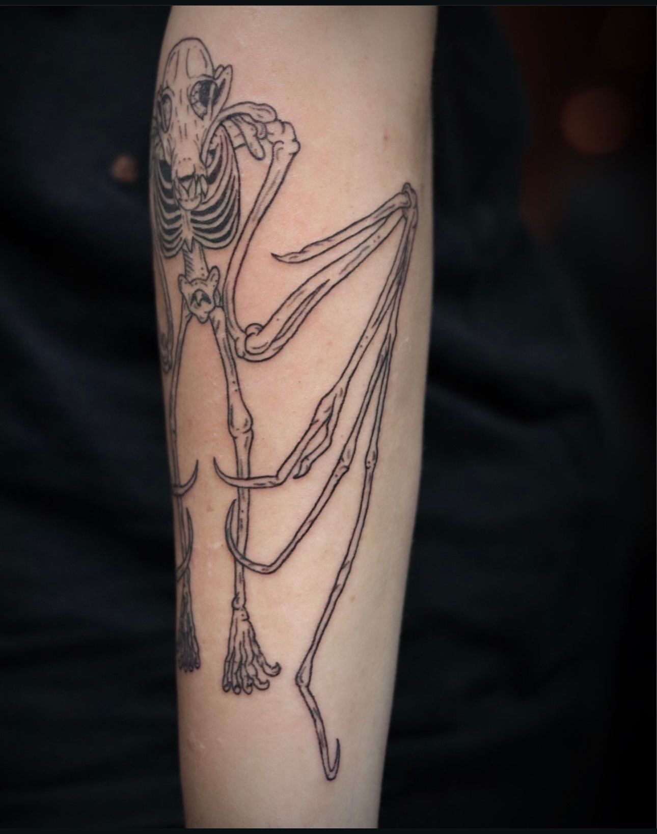 A tattoo of a skeleton on a person 's arm
