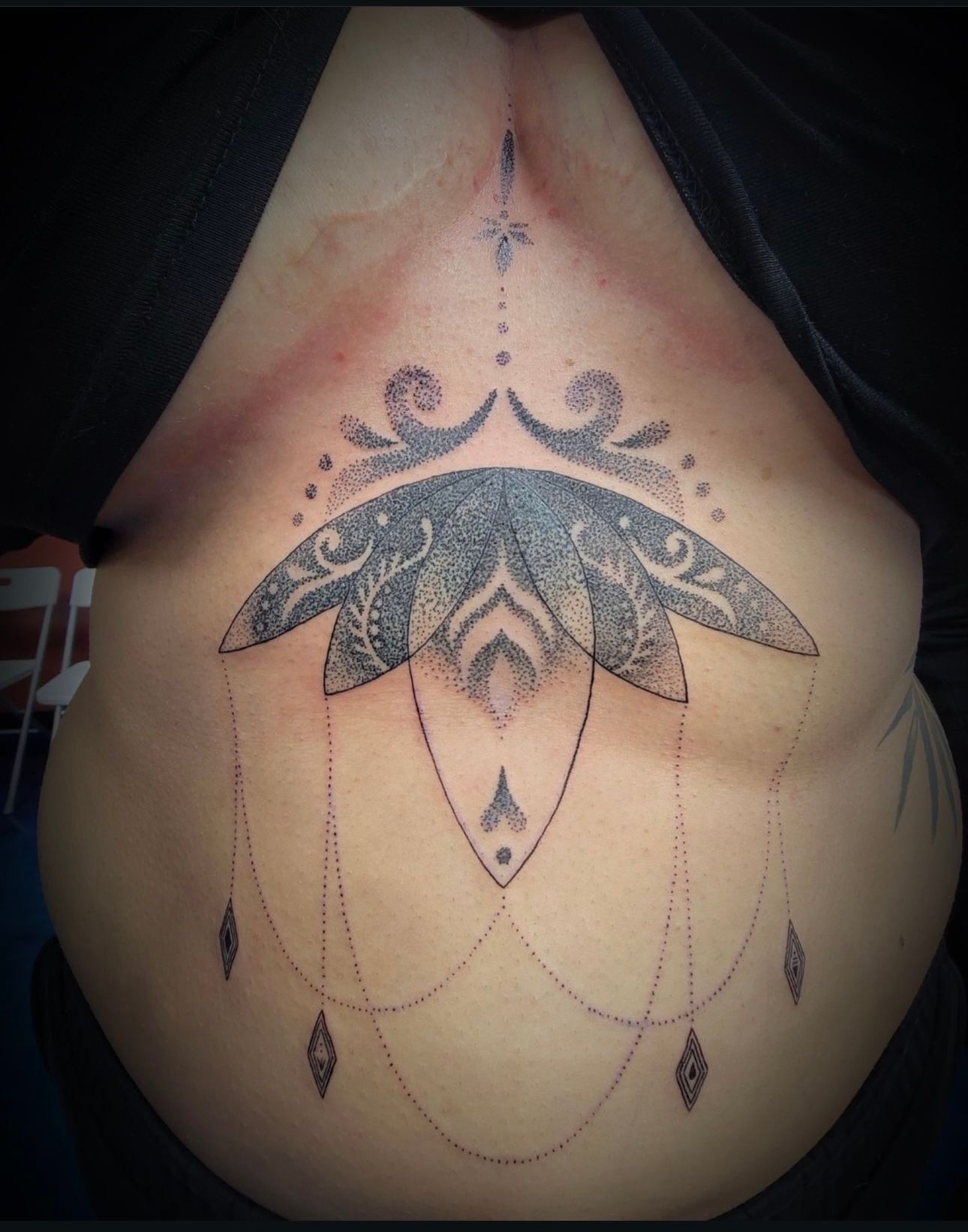 A woman has a black and white tattoo on her back