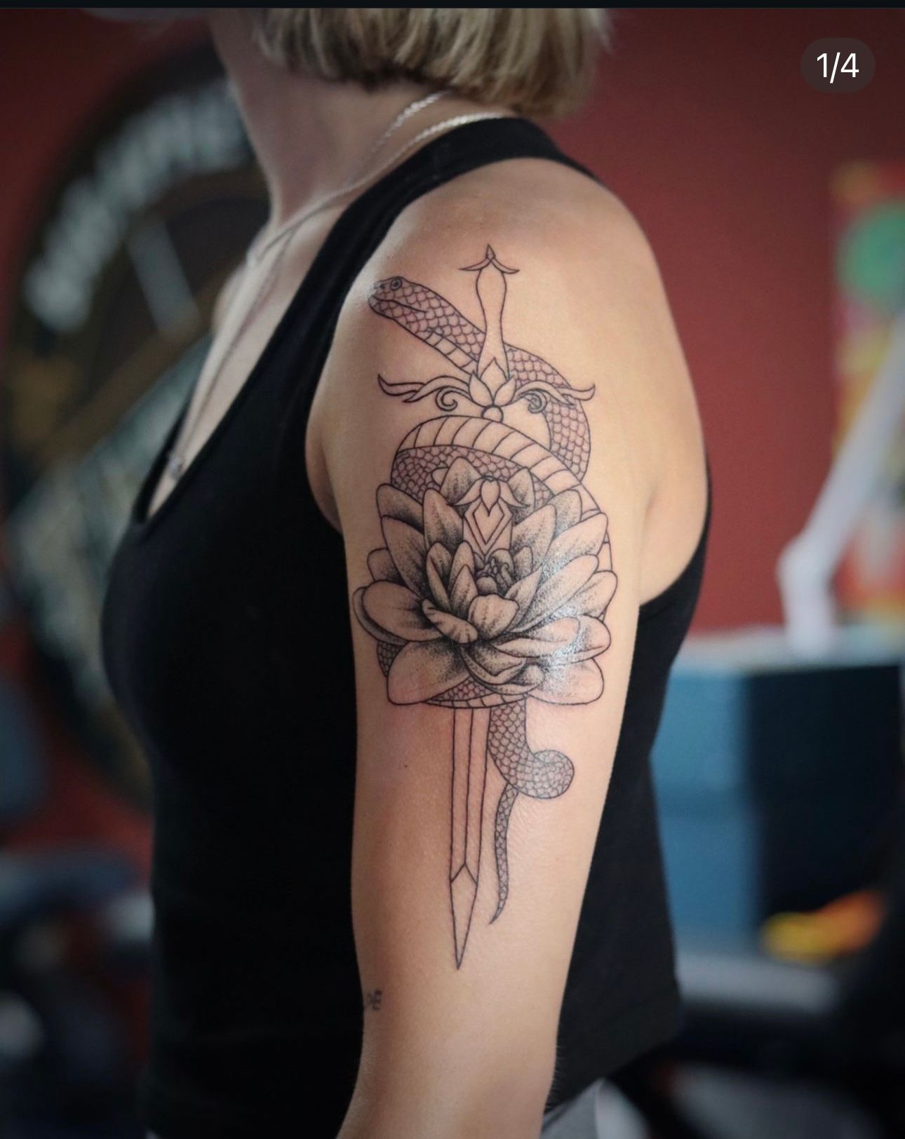 A woman has a tattoo of a flower and a snake on her arm