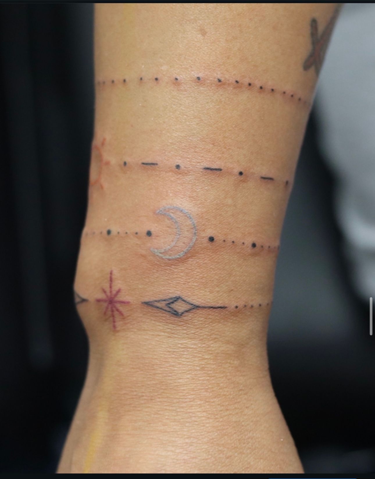 A person has a tattoo of a crescent moon on their wrist