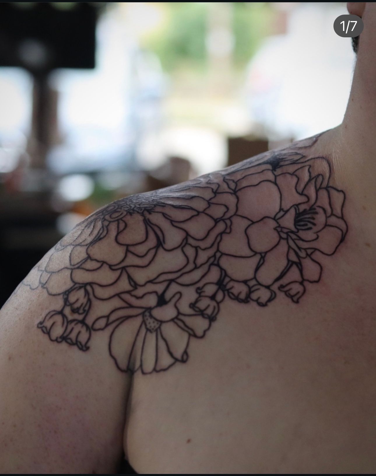 A woman has a tattoo of flowers on her shoulder