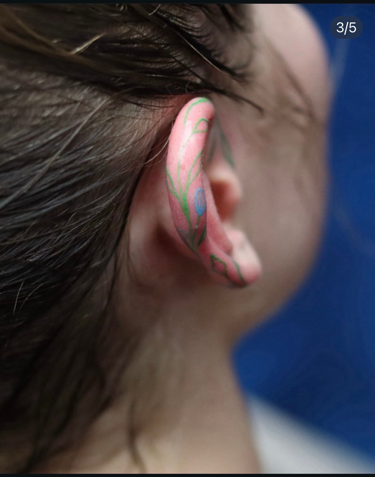 A close up of a person 's ear with a tattoo on it.
