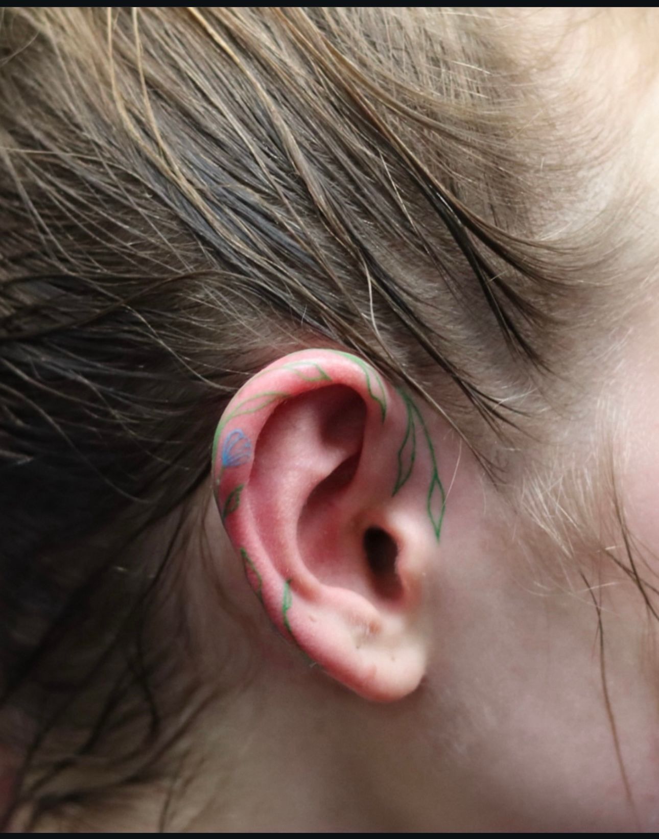 A close up of a person 's ear with a tattoo on it