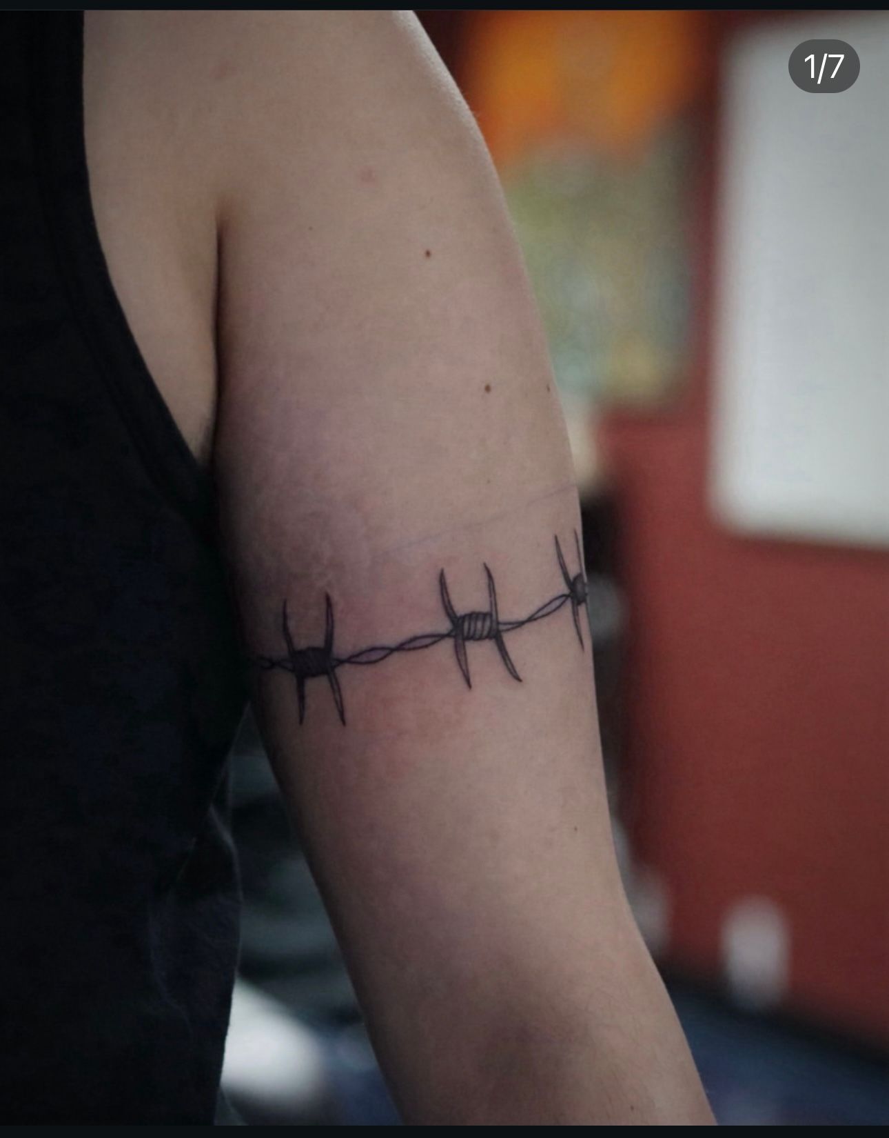 A person has a barbed wire tattoo on their arm