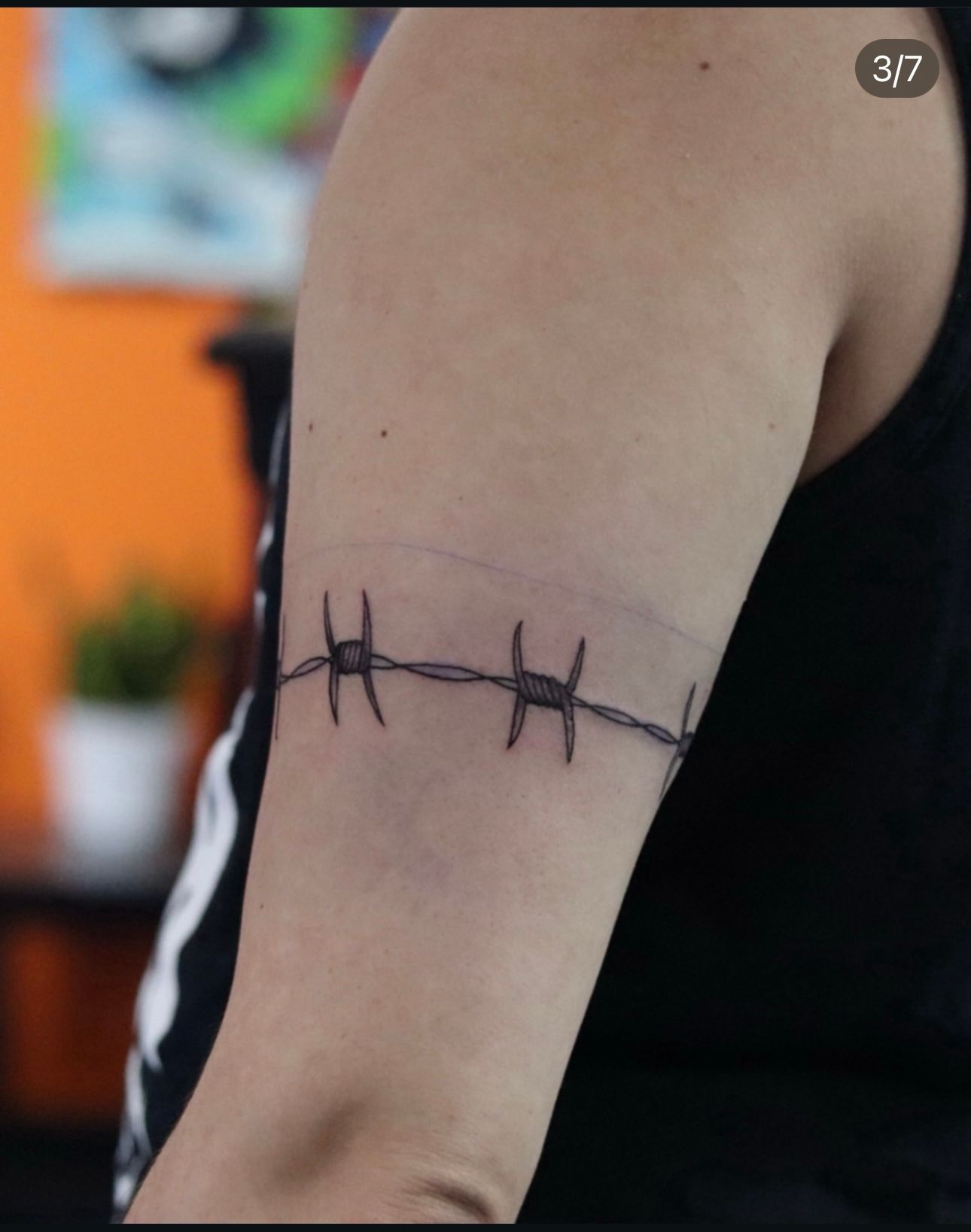 A person has a barbed wire tattoo on their arm