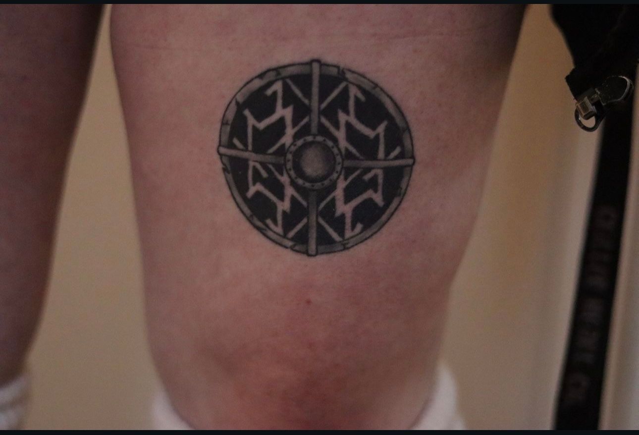 A person has a tattoo on their leg that looks like a cd