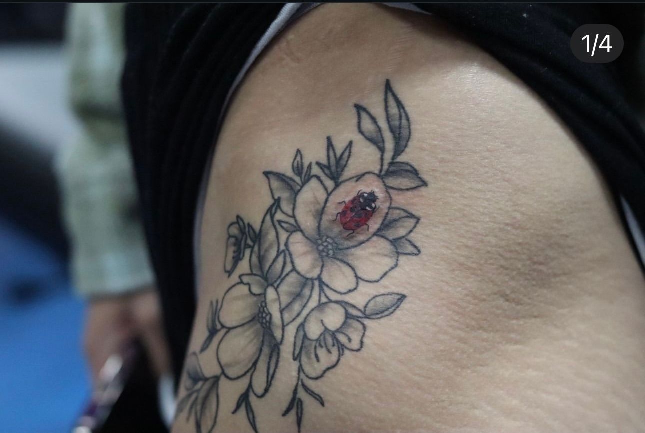 A woman has a tattoo of flowers on her shoulder
