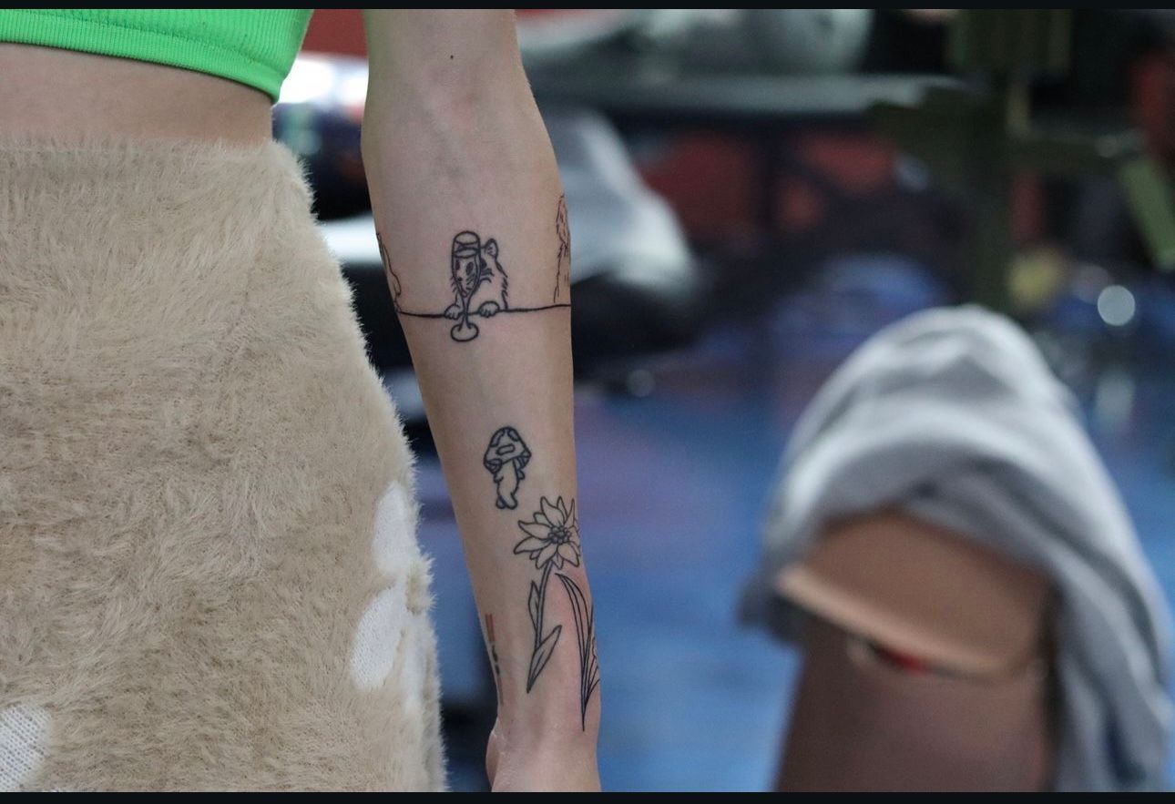 A woman has a tattoo on her forearm that looks like mushrooms